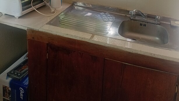 Una cocina con microondas, tostadora y pileta.