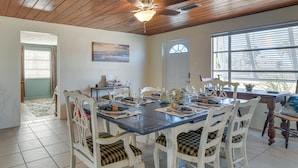 A dining area with a wooden ceiling, a large window, and a dining table set for four. - 2 Mi to Manasota Key Beaches: Coastal Getaway (Englewood)