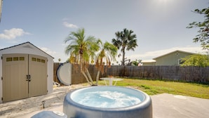 A backyard with a hot tub, a wooden fence, and palm trees. - 2 Mi to Manasota Key Beaches: Coastal Getaway (Englewood)