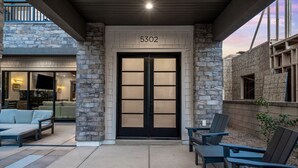 A modern entrance with a stone facade, a double door, and a number '5302' above it. - Modern Desert Color retreat designed for elevated group stays (St. George)