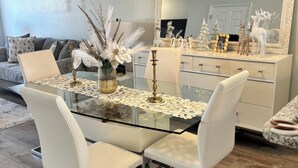 A dining area with a glass table, white chairs, and a decorative centerpiece. - Peaceful gated retreat/Waterfront/Clubhouse (Bradenton)