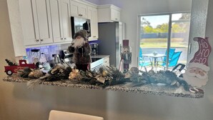 A kitchen with white cabinets, a red toy truck, and Christmas decorations including a nutcracker and a Santa Claus cutout. - Peaceful gated retreat/Waterfront/Clubhouse (Bradenton)