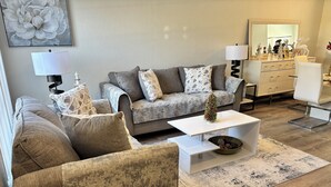 A living room with a grey sofa set, a white coffee table, and a patterned rug. - Peaceful gated retreat/Waterfront/Clubhouse (Bradenton)