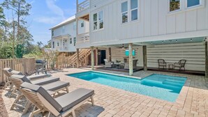 A two-story house with a swimming pool, outdoor seating, and a covered patio area. - Walk to Beach | Private Pool | Close to Shops (Santa Rosa Beach)