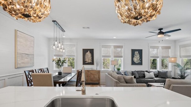 A modern kitchen with a large island, pendant lights, and a dining area with a table and chairs. - Walk to Beach | Private Pool | Close to Shops (Santa Rosa Beach)