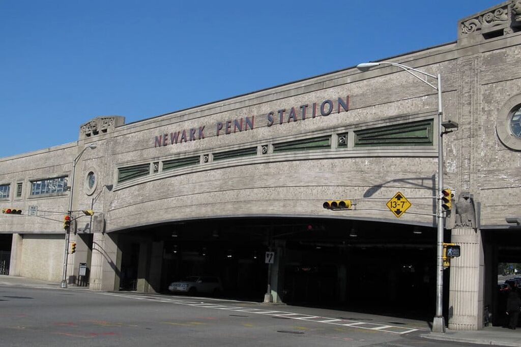 The exterior of Newark Penn Station with a large arched entrance and signage.