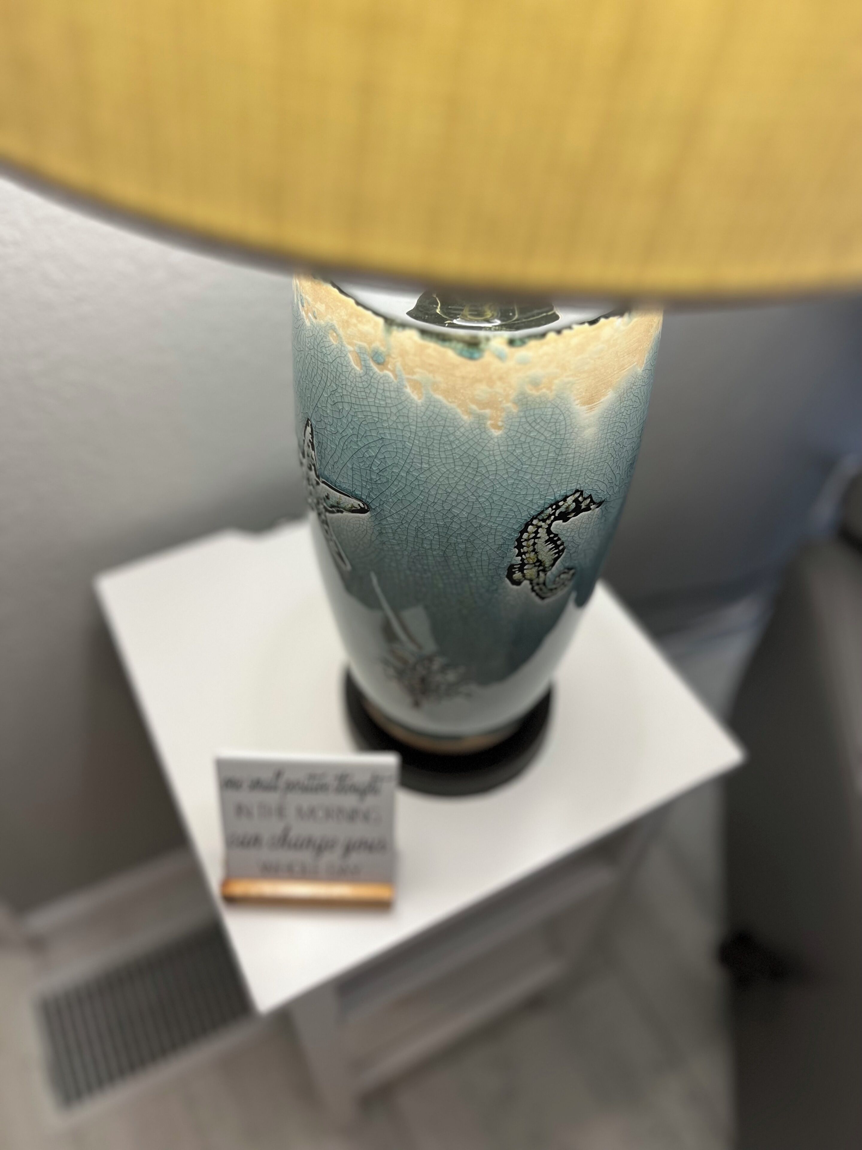 A decorative lamp with a globe design on a white pedestal.