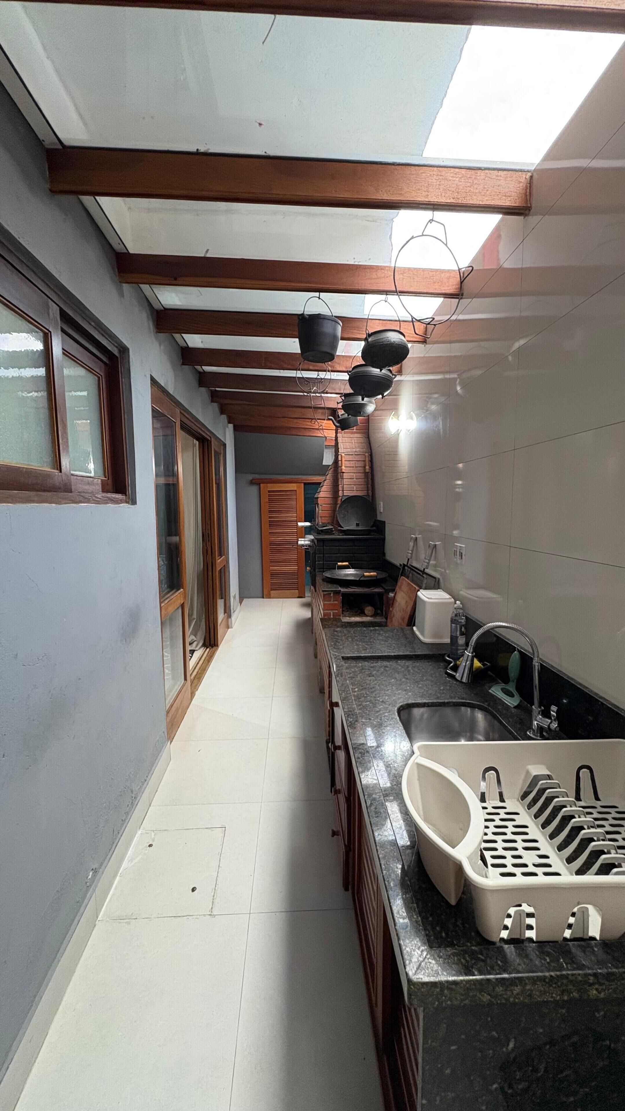 A narrow kitchen with a long countertop, a sink, and a built-in oven.