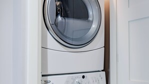 Eine übereinander gestellte Waschmaschine und ein Trockner in einem Hauswirtschaftsraum.