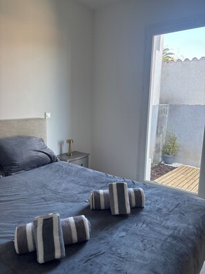 Une chambre à coucher avec un lit, une table de chevet et une vue sur l’extérieur.