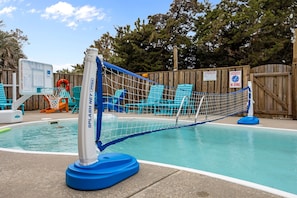 A pool area with a splash net, blue chairs, and a wooden fence. - Luxury Retreat w/SOUND VIEWS! Private Pool & Arcade (Salvo)
