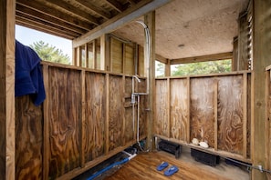 A wooden cabin with a shower, a towel hanging, and a pair of flip-flops on the floor. - Luxury Retreat w/SOUND VIEWS! Private Pool & Arcade (Salvo)