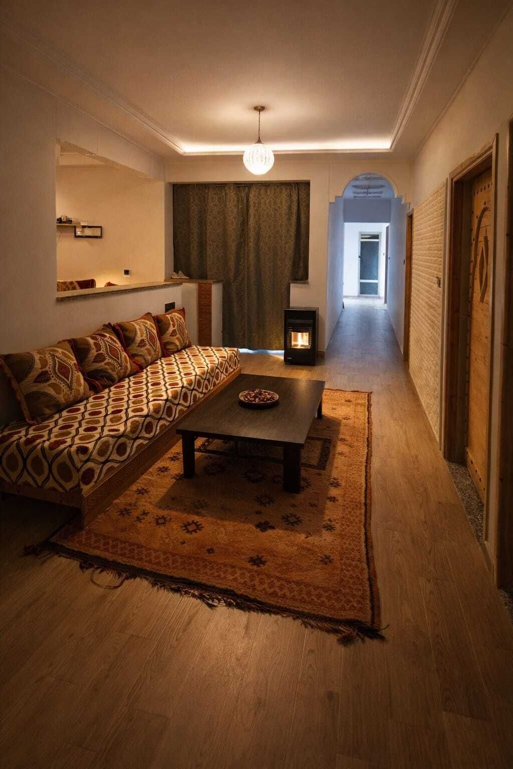 A cozy living room with a patterned sofa, a coffee table, and a fireplace.