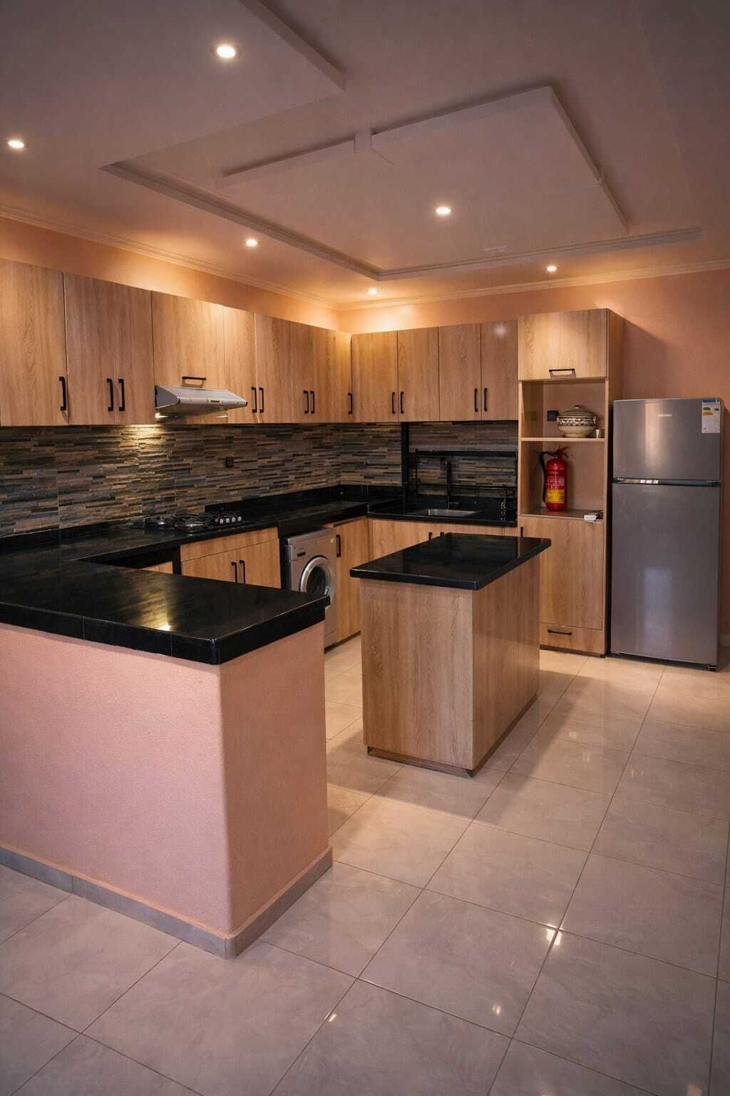 Una cocina moderna con armarios de madera, encimera negra, refrigerador de acero inoxidable y suelo de baldosas.