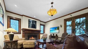 A cozy living room with a fireplace, comfortable seating, and large windows. - Elegant Historic Home near University of Rochester (Rochester)