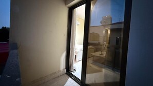A room with a sliding glass door leading to an outdoor area. - Perfect 1-bedroom villa with AC in charming Abu Dhabi (Abu Dhabi)