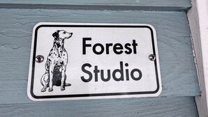 A sign with a dog illustration and the text "Forest Studio" on a light blue wall.