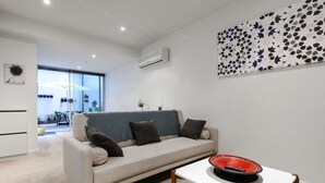 Un salon moderne avec un canapé, une table basse et un élément décoratif mural.