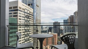 A balcony with two chairs and a table, overlooking a cityscape with modern buildings. - MHYL # CBD stylish 1BR Apt with city view (Melbourne)
