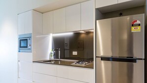A modern kitchen with a built-in microwave, gas stove, and stainless steel refrigerator. - MHYL # CBD stylish 1BR Apt with city view (Melbourne)