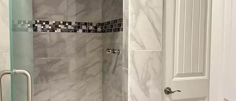 Een douche, handdoeken, zeep, toiletpapier