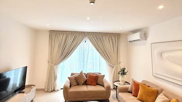 Apartamento Deluxe, vistas a la ciudad | Zona de estar | Smart TV de 50 pulgadas con canales digitales