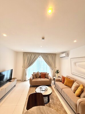 Apartamento Deluxe, vistas a la ciudad | Zona de estar | Smart TV de 50 pulgadas con canales digitales