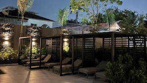 Uma área de estar ao ar livre com espreguiçadeiras e uma estrutura de pérgola.