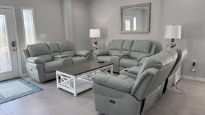 Ein modernes Wohnzimmer mit einem Ecksofa, einem Couchtisch und zwei Wandleuchten.