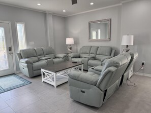 Ein modernes Wohnzimmer mit einem Ecksofa, einem Couchtisch und zwei Wandleuchten.