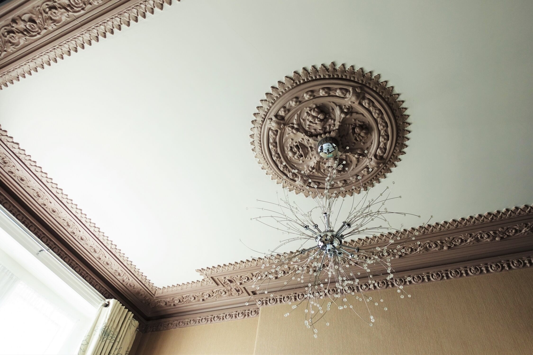 Techo con un diseño ornamentado y una lámpara de araña.