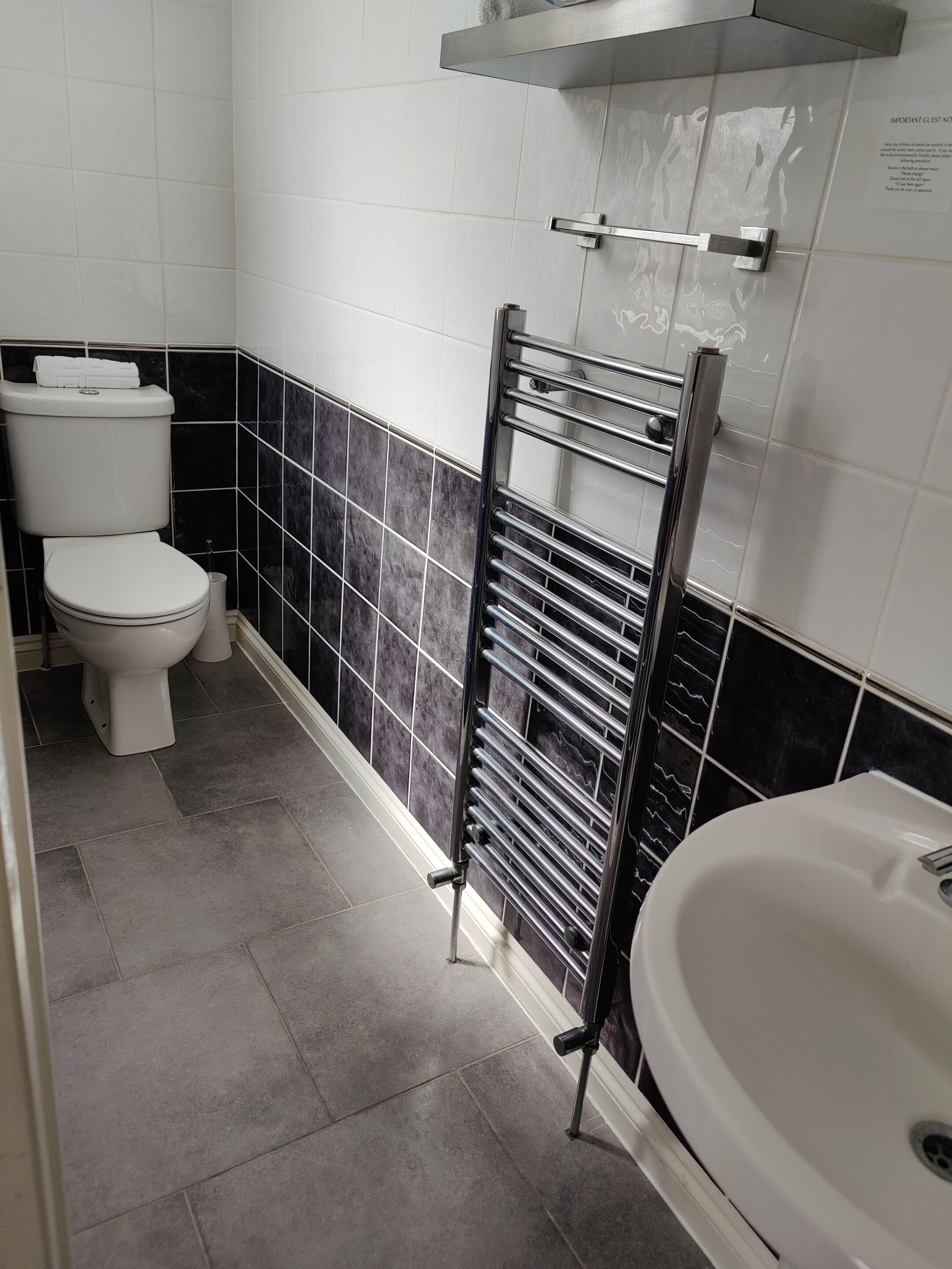 Ein Badezimmer mit Toilette, Handtuchhalter und Waschbecken.