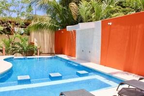 A swimming pool with a tiled deck, surrounded by a low orange wall and a white tiled wall. - Altamar Playa La Ropa - 5 Bedrooms - 10 King - Swimming Pool - 400 m Beach - 20 People (Zihuatanejo)