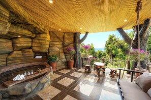 Ein Wellnessbereich mit Steinwand, Holzboden und Meerblick.