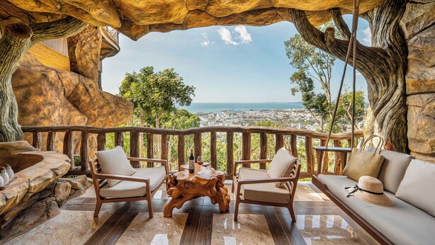 Une terrasse offrant une vue sur le paysage urbain, aménagée avec une table, des chaises et un canapé.