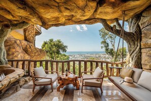 Eine Terrasse mit Blick auf eine Stadtlandschaft, ausgestattet mit einem Tisch, Stühlen und einer Couch.