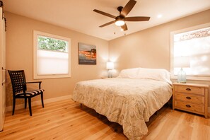A bedroom with a bed, a chair, a nightstand, a lamp, a ceiling fan, and a window with blinds. - Adorable 2-bedroom house near downtown Paso Robles (Paso Robles)