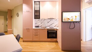 Eine moderne Küche mit Marmorfliesenspiegel, Holzschränken und einem eingebauten Backofen.