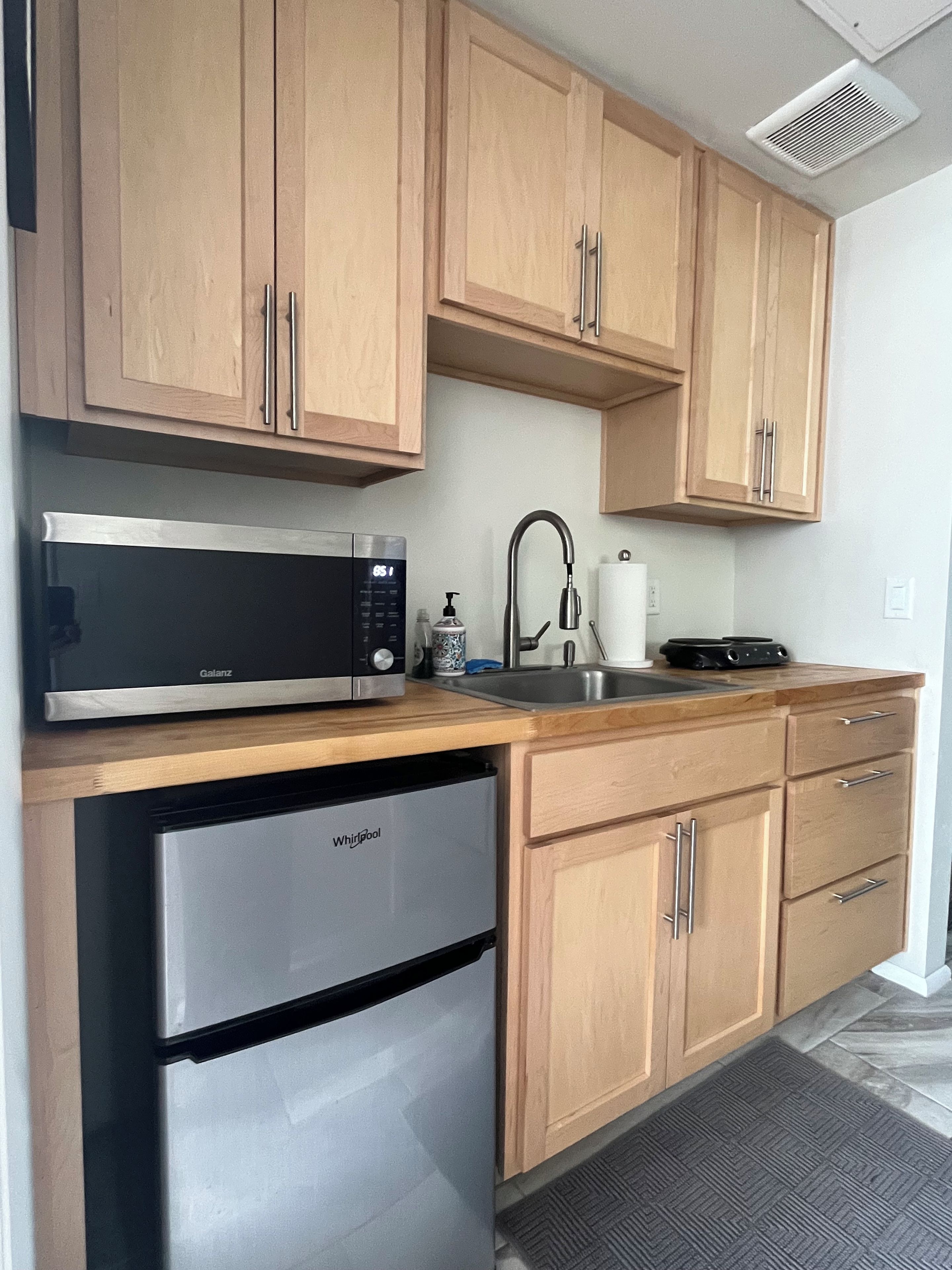 A kitchen with wooden cabinets, a microwave, a dishwasher, and a sink.