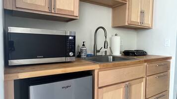 A kitchen with wooden cabinets, a microwave, a dishwasher, and a sink.