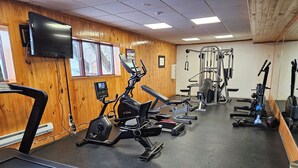 A gym with cardio machines, weightlifting equipment, and a mirrored wall. - Lovely 3-bedroom lodge with fitness room in Park City (Park City)