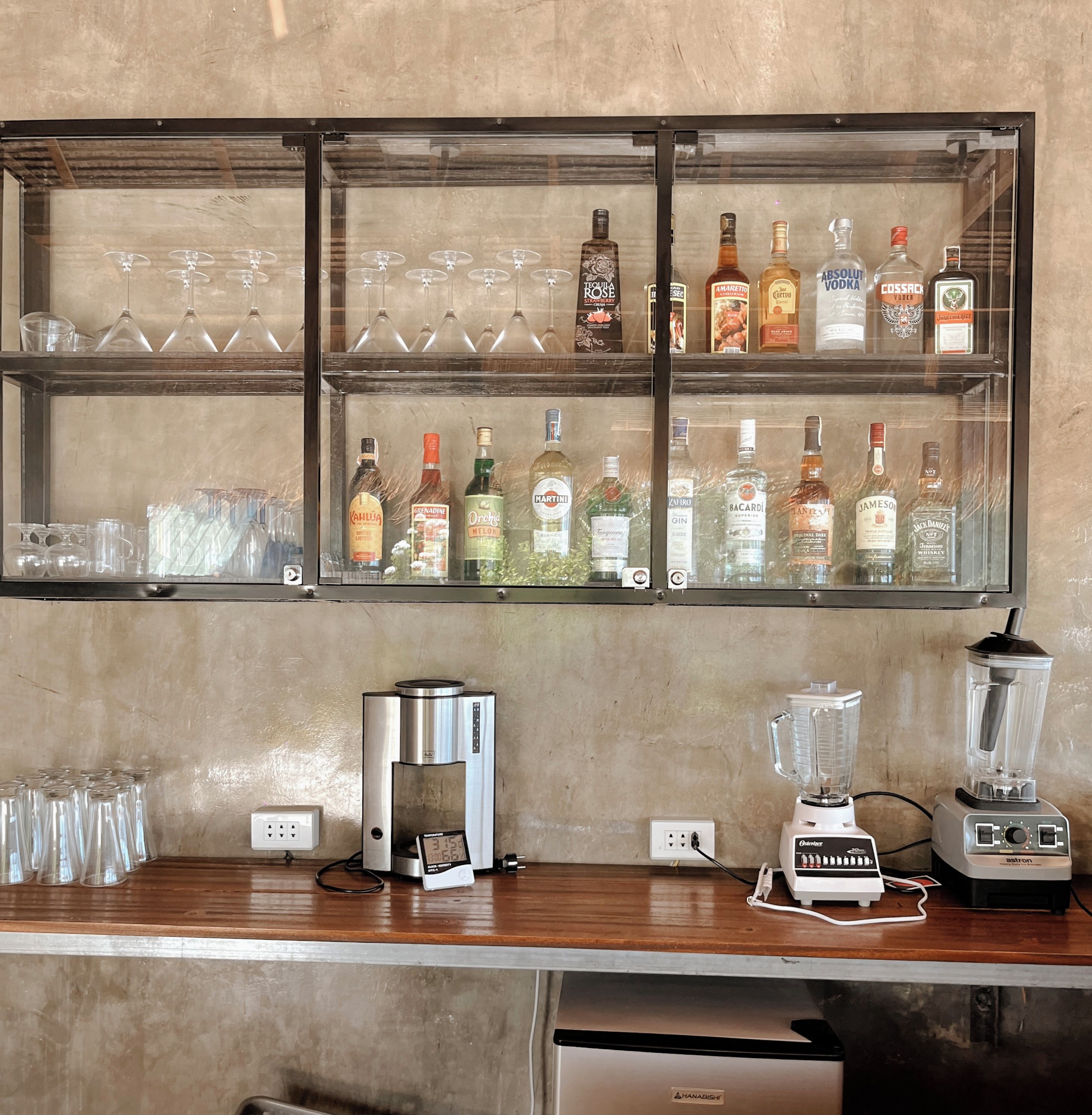 A bar area with shelves of liquor bottles and glasses.