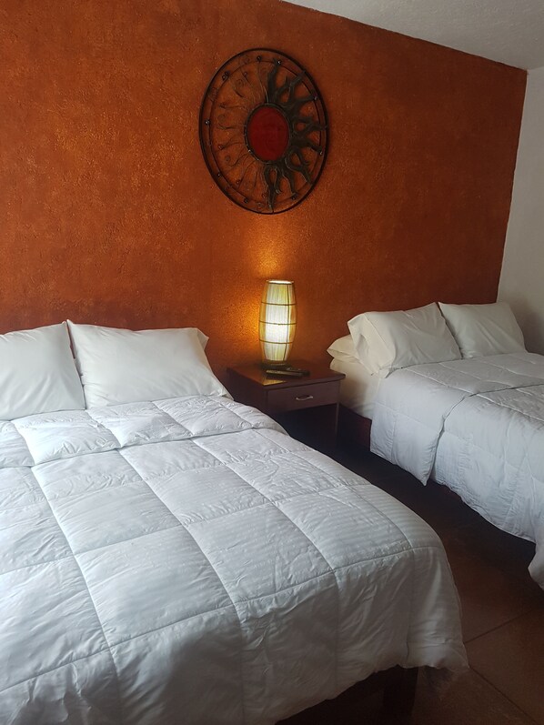 Ein Hotelzimmer mit zwei Betten, einem Nachttisch mit Lampe und einem dekorativen Wandbild.
