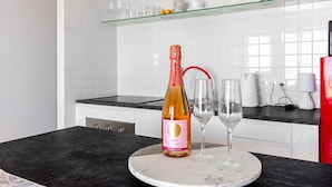 A kitchen with a marble countertop, a bottle of rosé wine, and two glasses. - Capistrano Village, 1 Bedroom (Nerja)