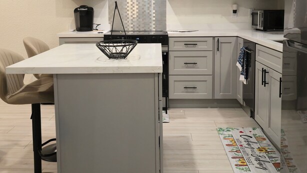 A modern kitchen with a central island, white cabinets, a stainless steel range hood, and a microwave. - Cozy luxury-1 bedroom guest suite in Concord -walk to BART-close to Mt Diablo. (Concord)
