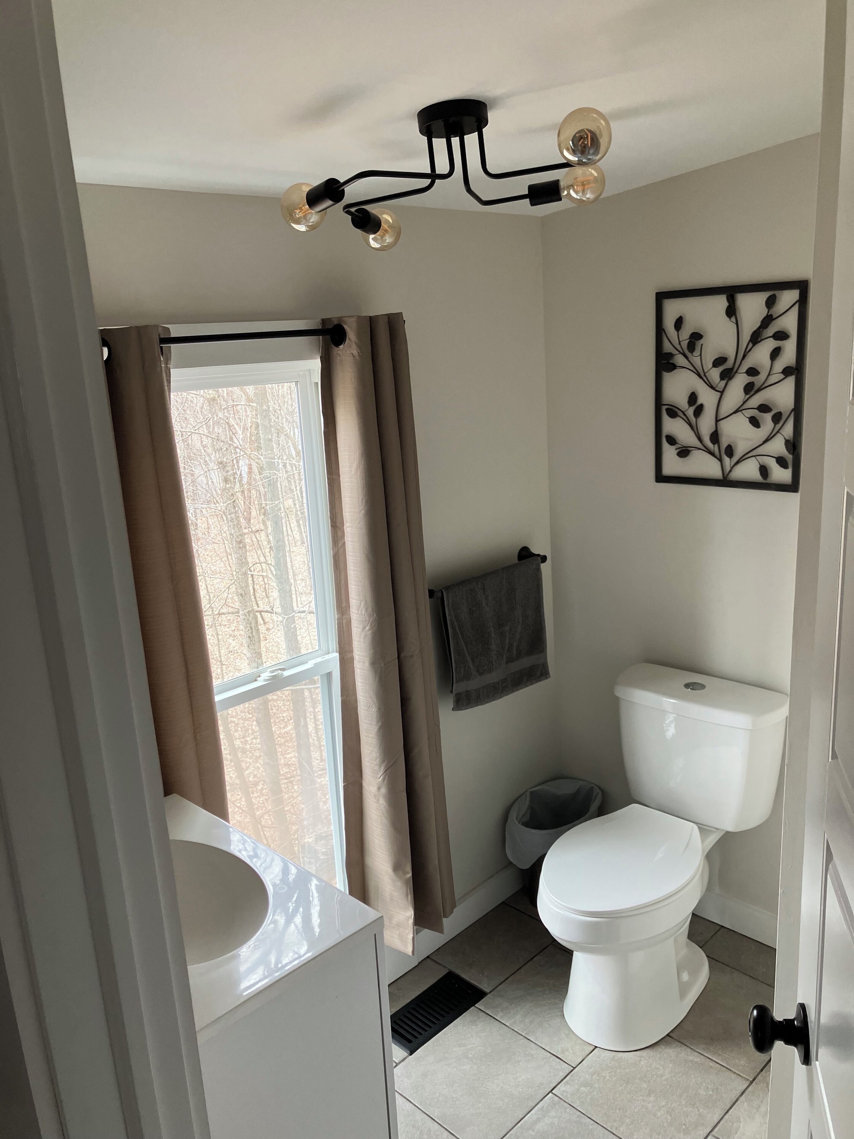 A bathroom with a toilet, sink, and shower curtain.
