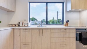 Eine moderne Küche mit einem großen Fenster, einem eingebauten Backofen und einer Spüle.