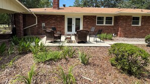 A brick house with a covered patio, outdoor furniture, and a small garden area. - 4 BR/3 BA-Great for extended stays- Close to Savannah River Site & Masters Golf (Aiken)