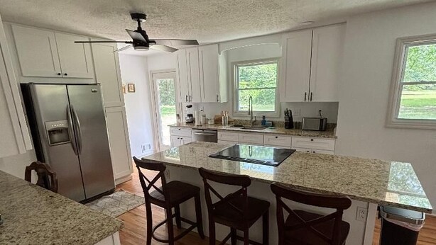 A kitchen with a central island, bar stools, a refrigerator, and a ceiling fan. - 4 BR/3 BA-Great for extended stays- Close to Savannah River Site & Masters Golf (Aiken)