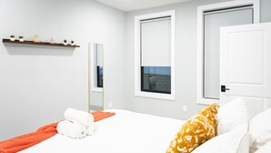 Ein Hotelzimmer mit Bett, Spiegel, Fenster und Tür.